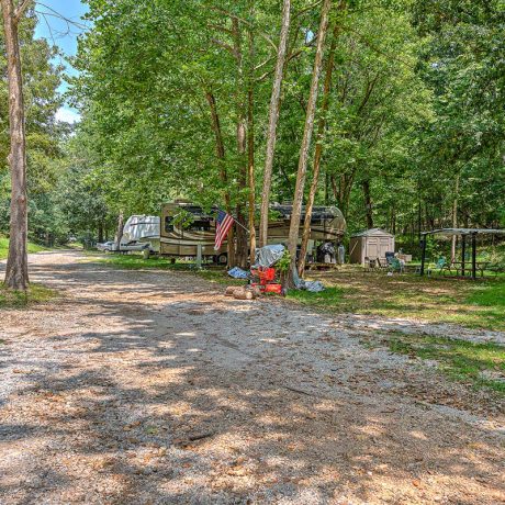 rv parked off road between trees